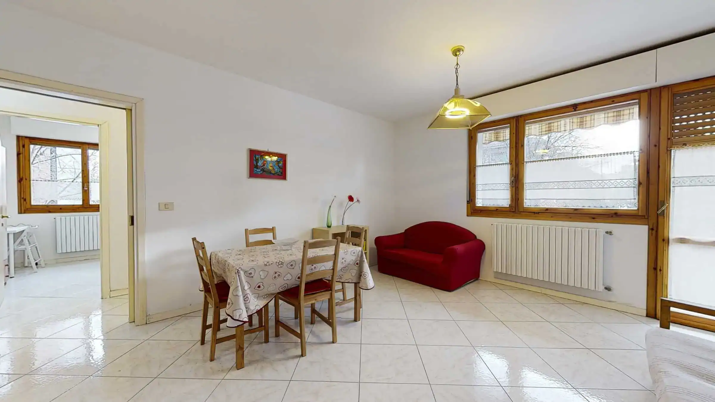 sala da pranzo con tavolo e divano rosso
