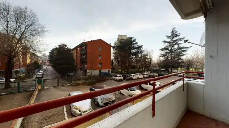 balcone con ringhiera rossa e vista su strada