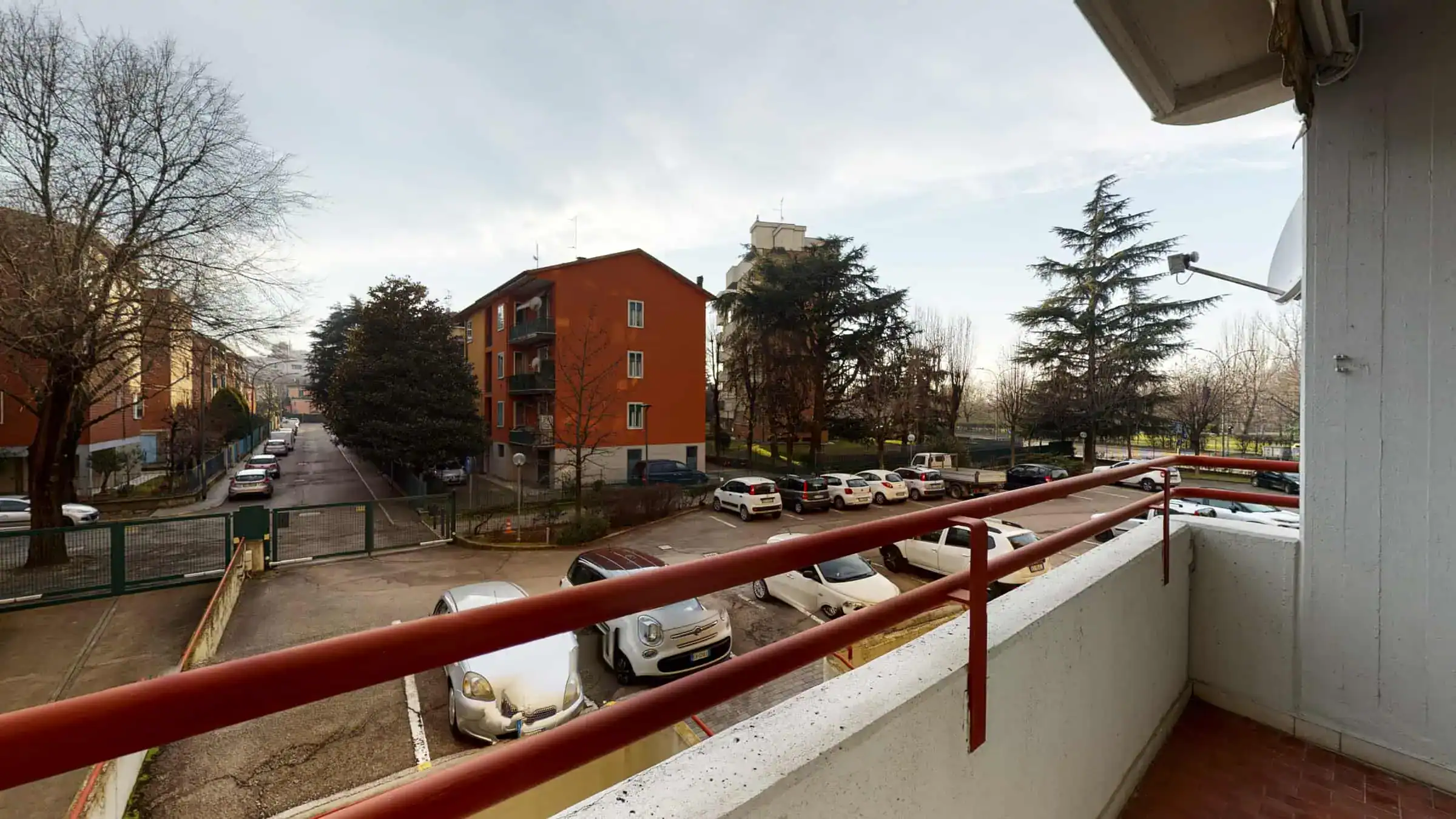 vista da un balcone con alberi e auto parcheggiate