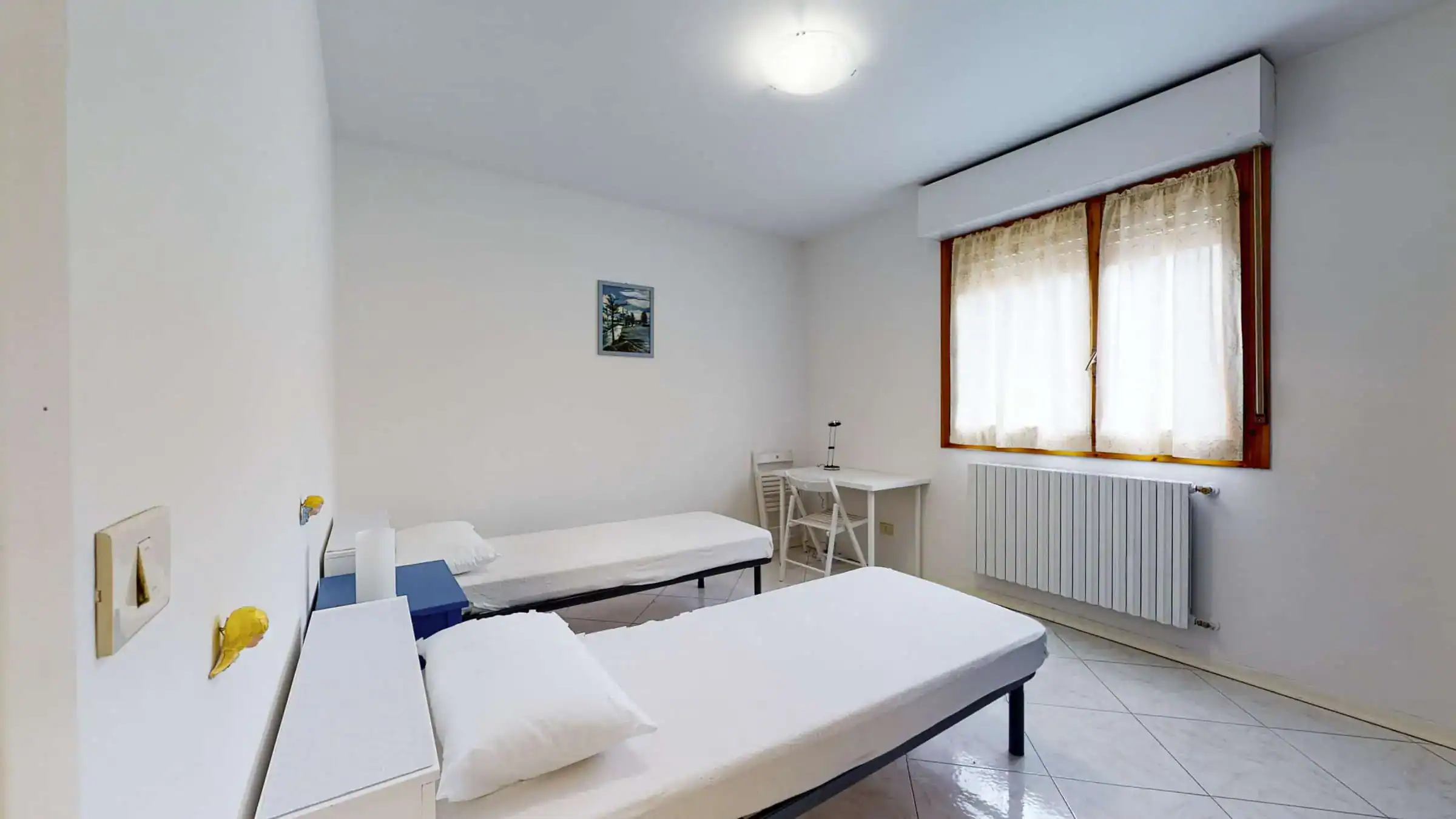 camera con letti singoli vicino a una finestra