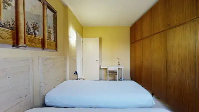 camera con letti singoli e armadio in legno