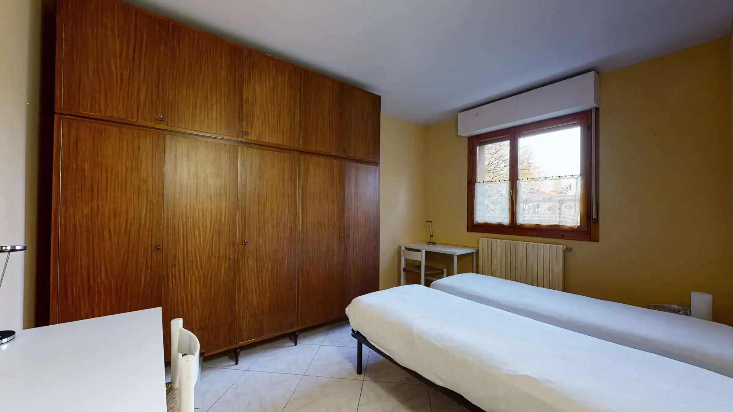 camera con letti singoli e armadio in legno