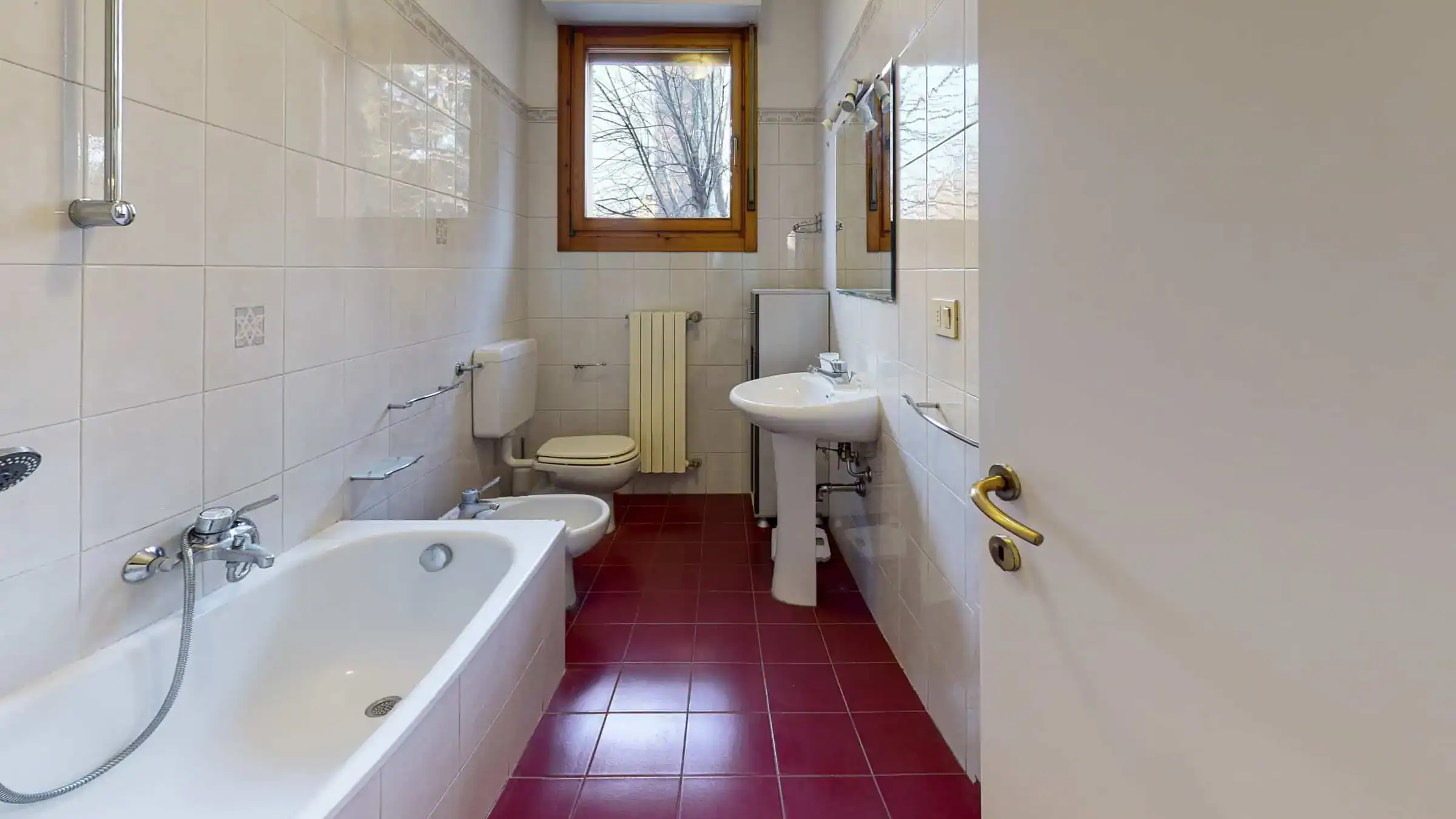 bagno con vasca e finestra su un muro bianco