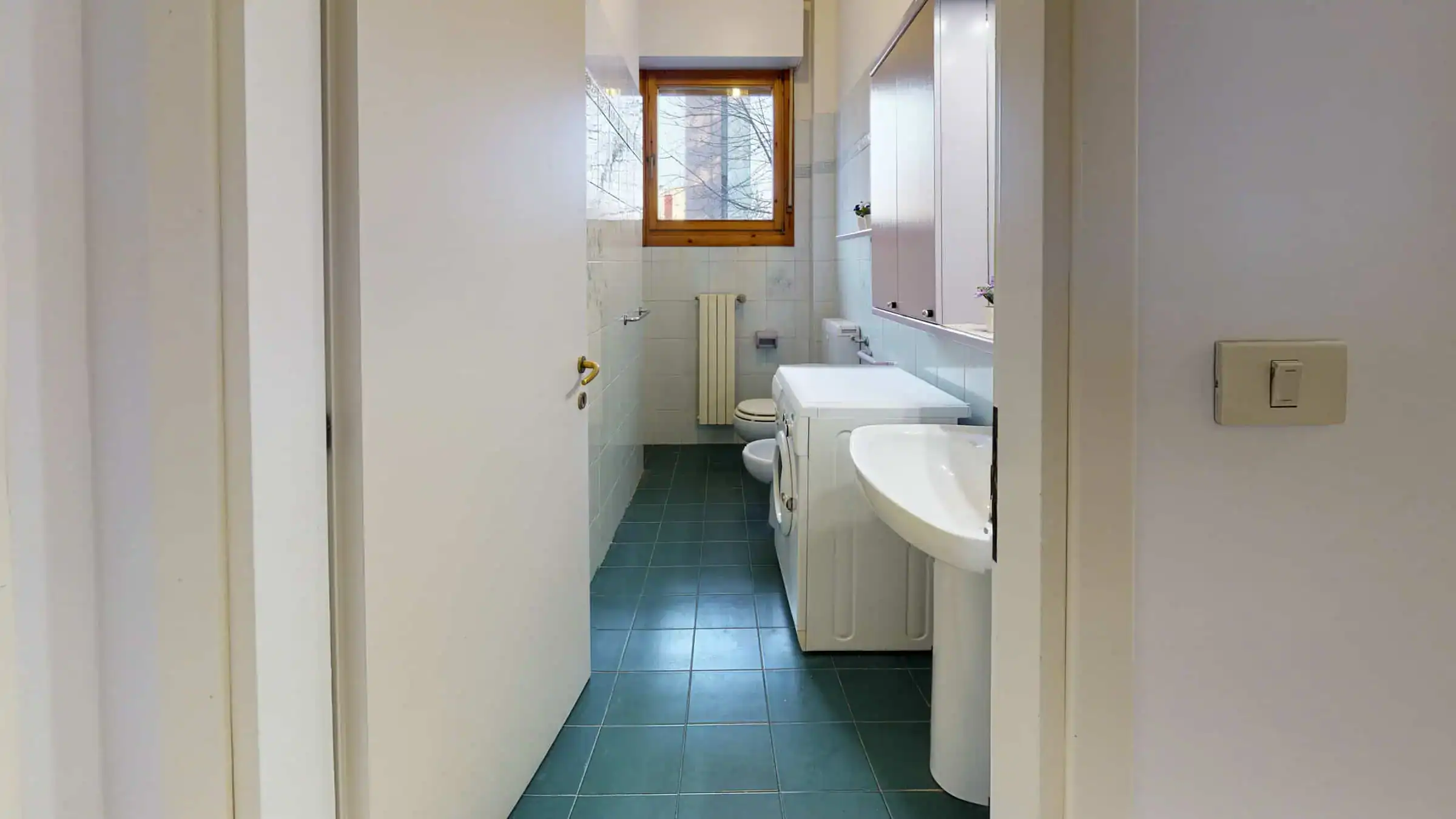 bagno con piastrelle verdi e finestra