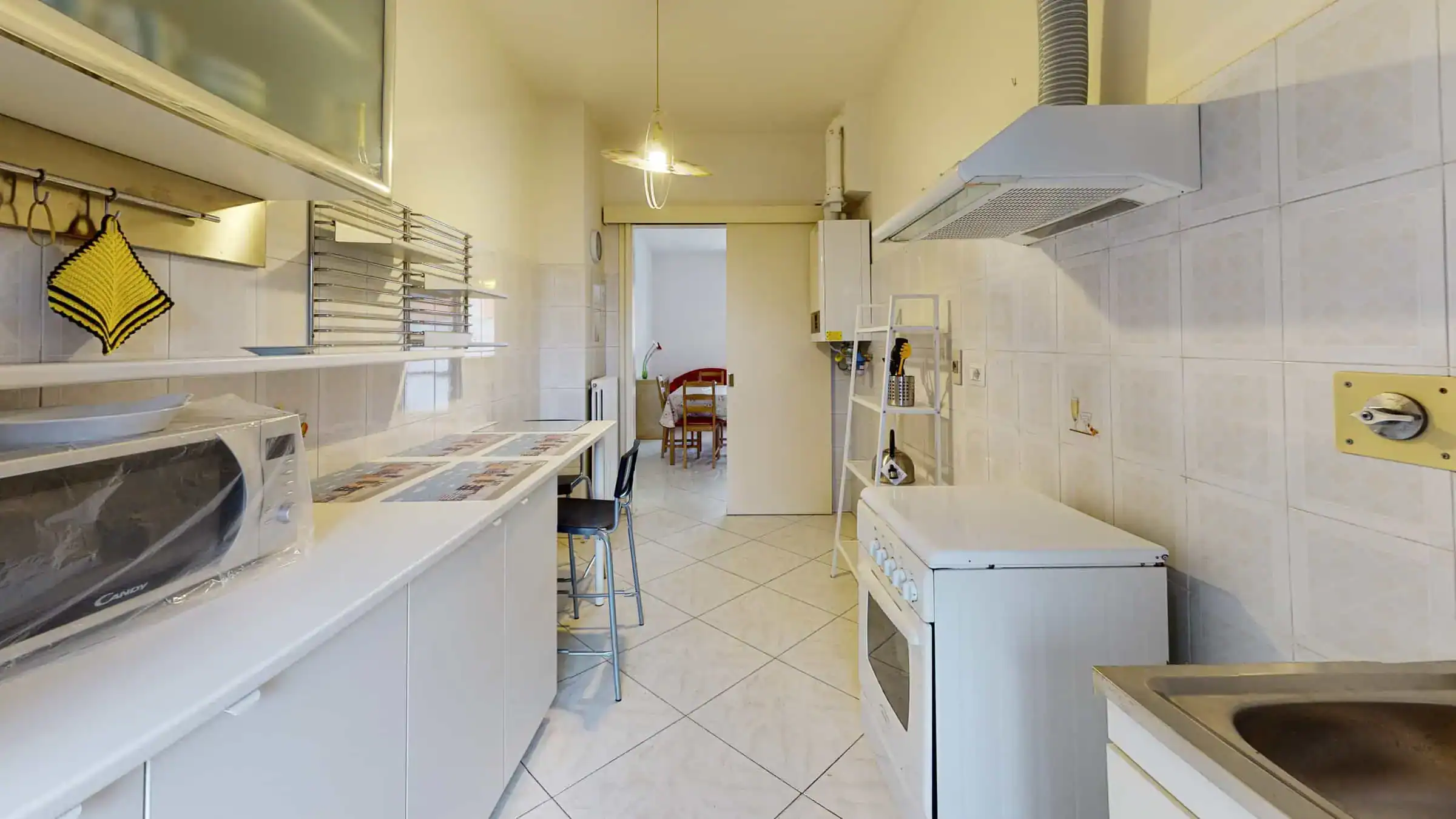 cucina con elettrodomestici bianchi e tavolo in legno