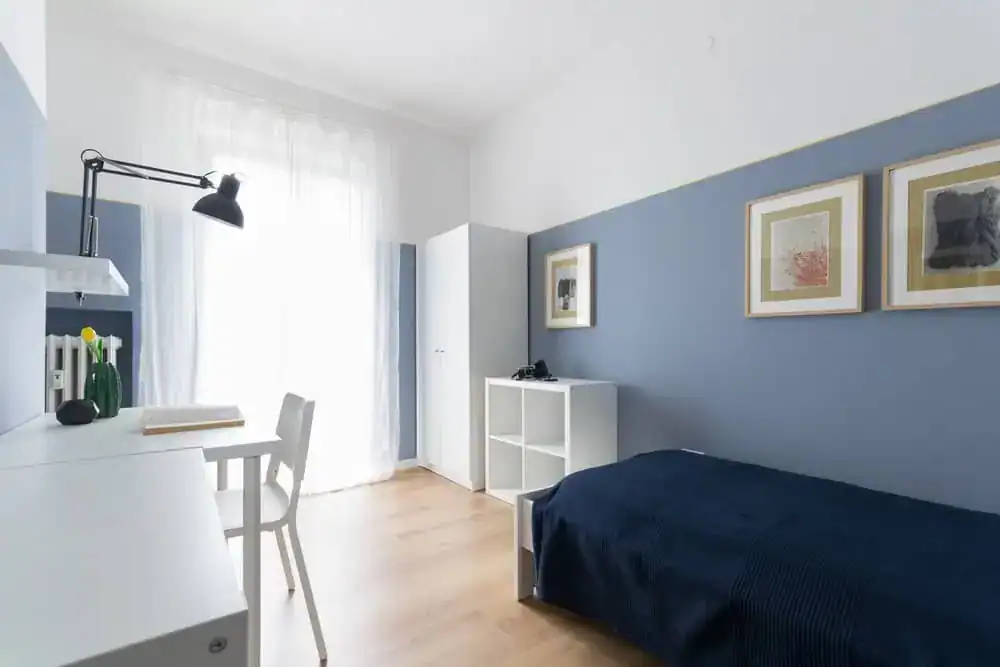 camera con letto e scrivania vicino alla finestra