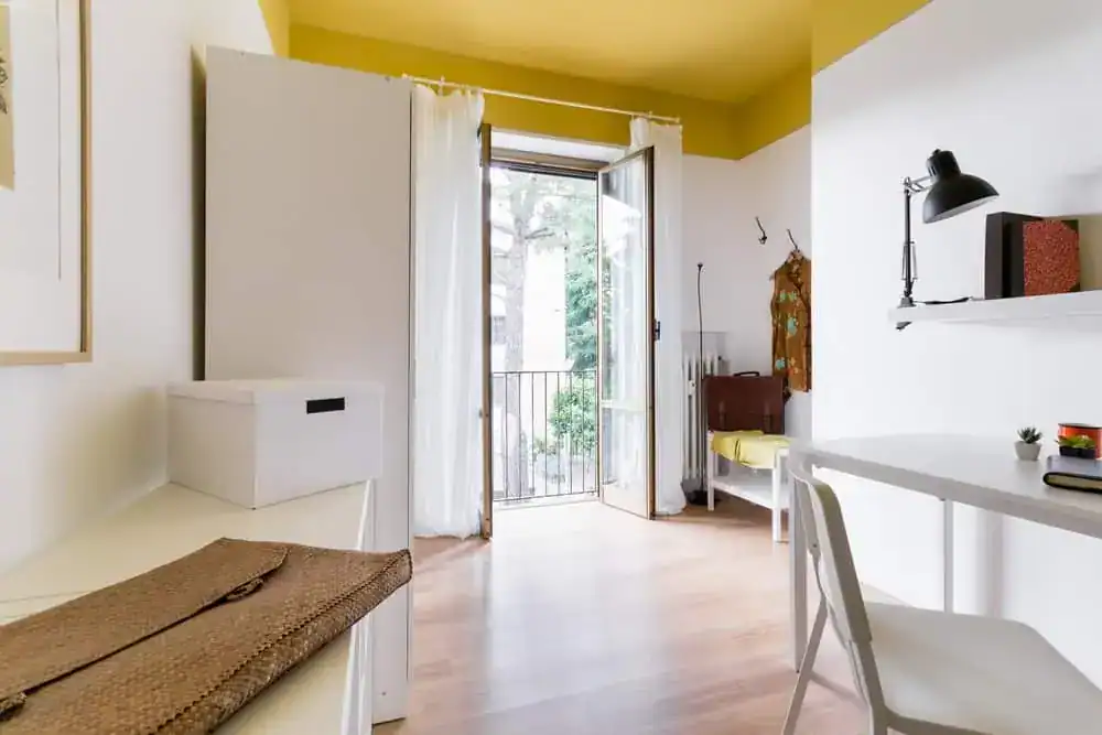 camera con scrivania e balcone aperto