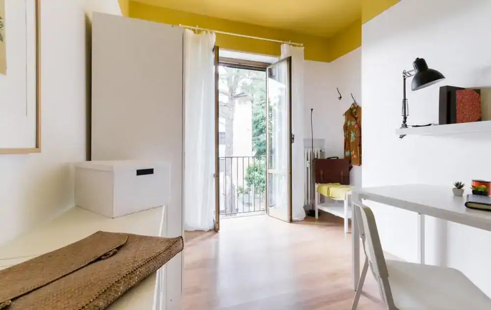 camera con scrivania e balcone aperto