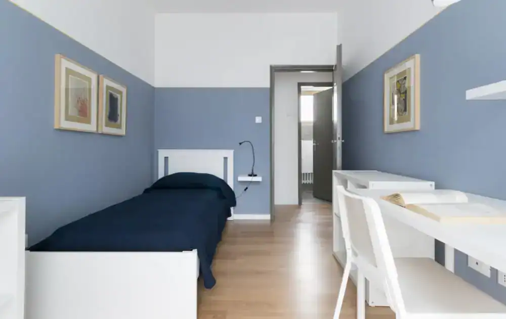 camera con letto singolo e scrivania vicino alla porta