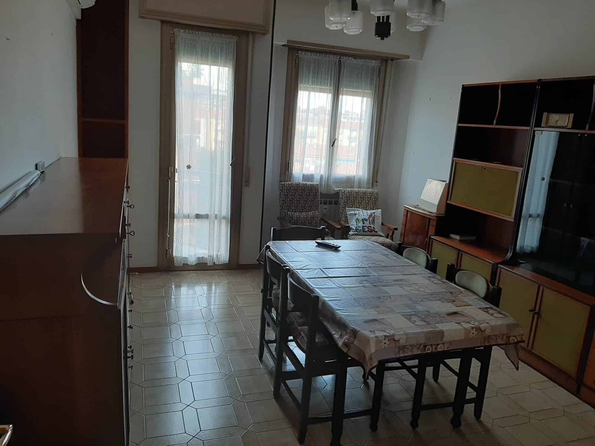 sala da pranzo con tavolo e sedie vicino a finestre
