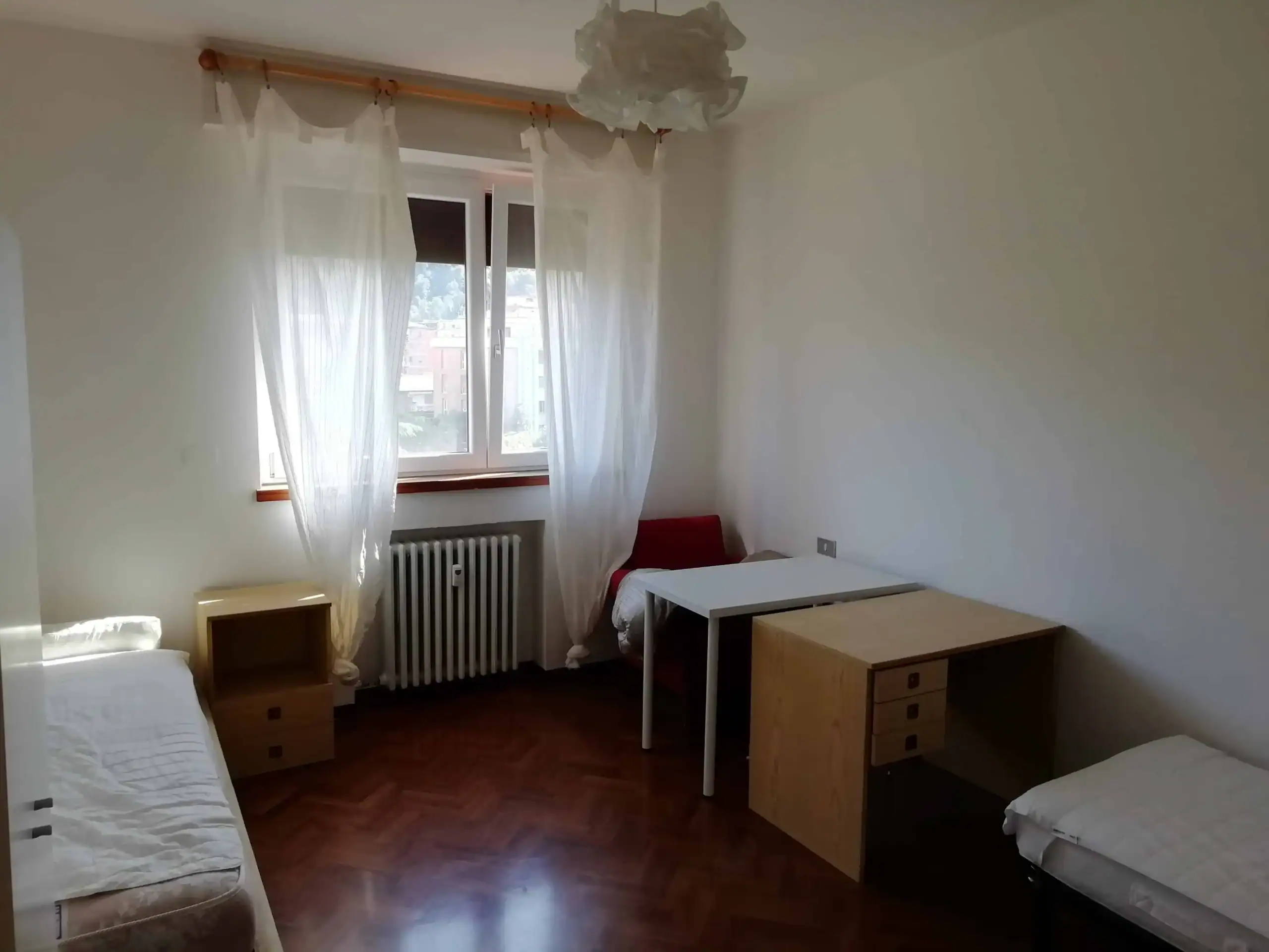 camera con letti e scrivania vicino alla finestra