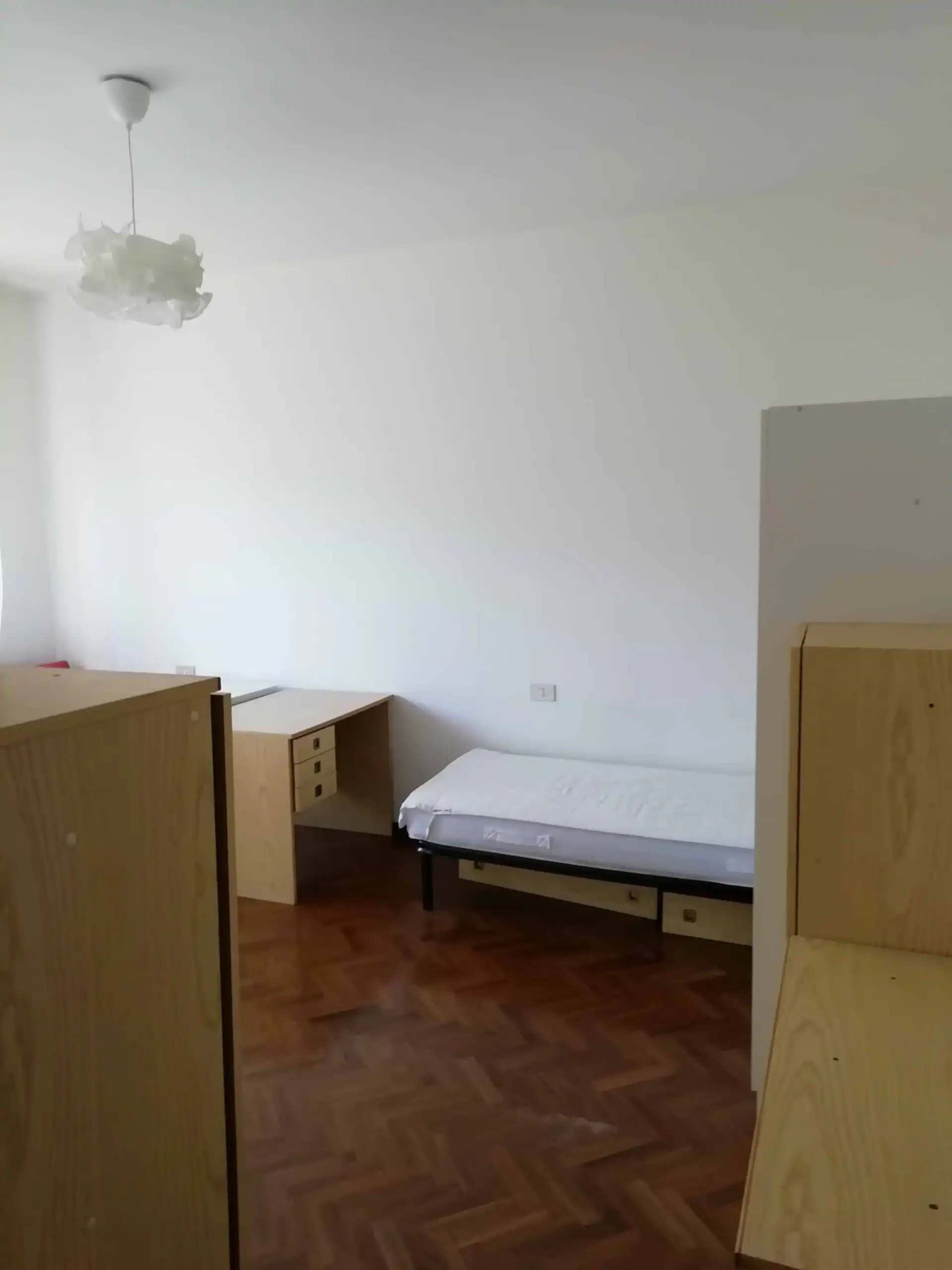 camera con letto e scrivania in legno