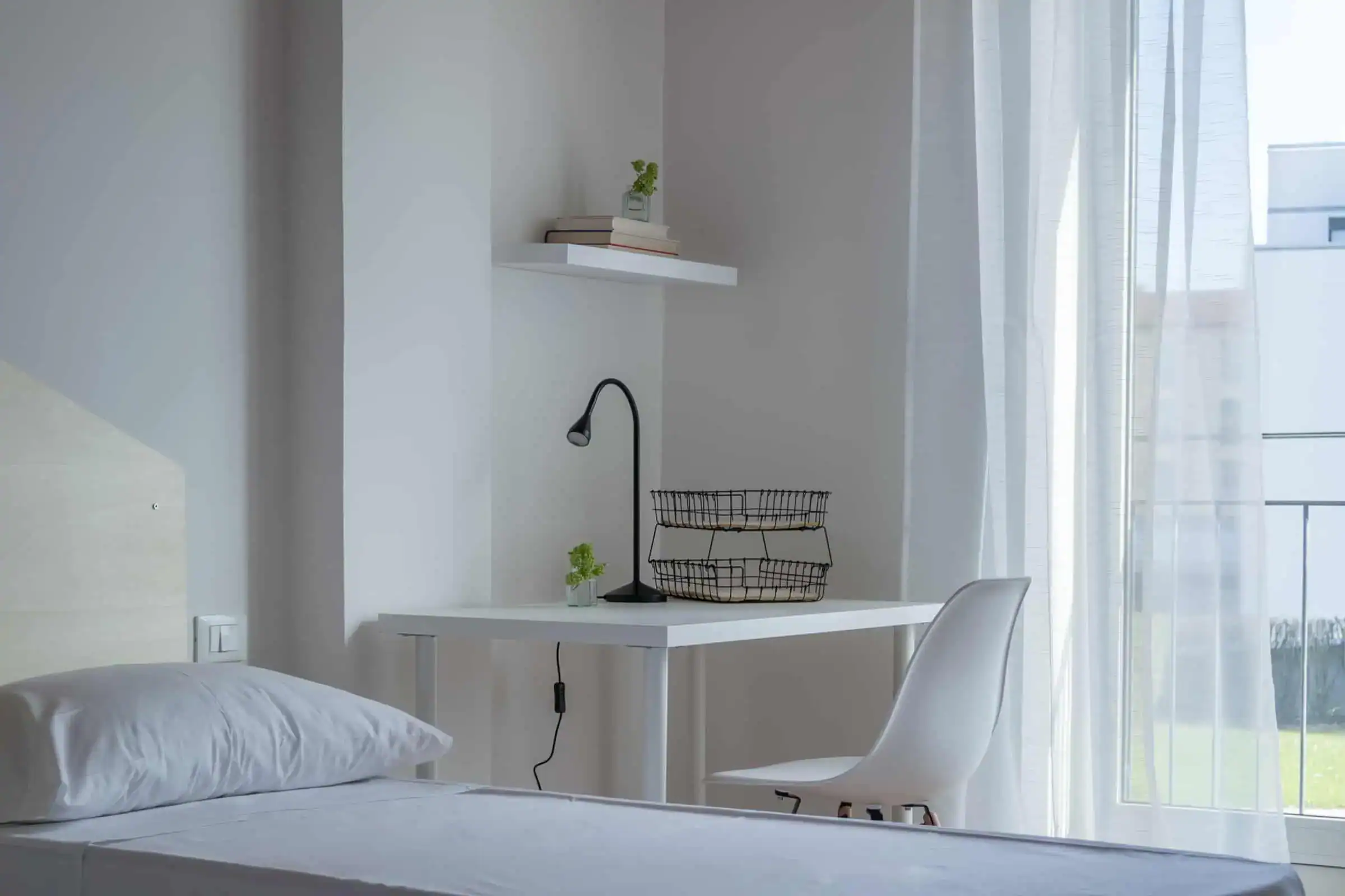 camera con letto e scrivania vicino alla finestra