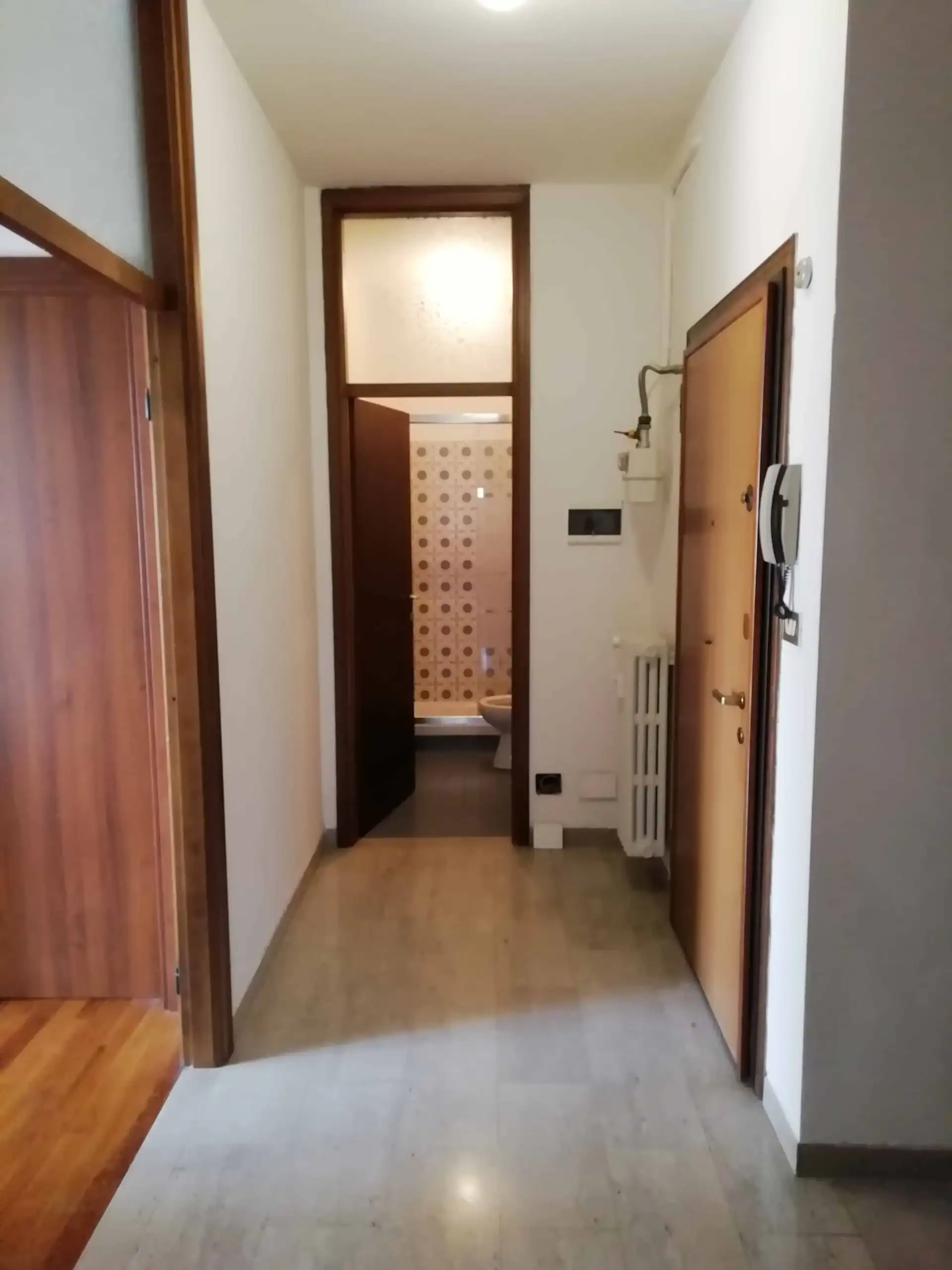 corridoio con porte in legno e pavimento chiaro