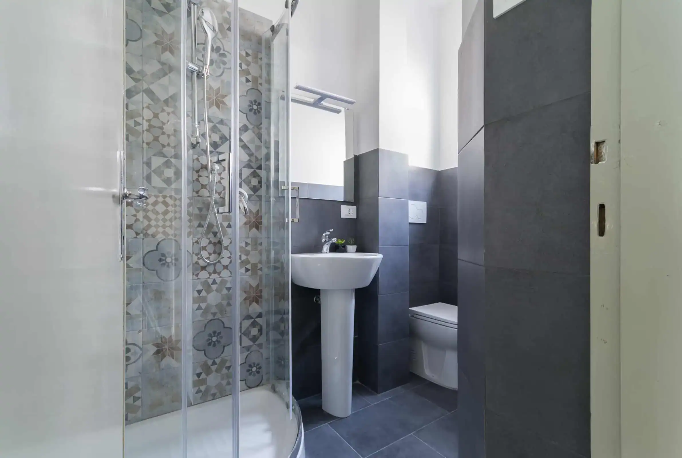 bagno moderno con doccia in vetro e piastrelle decorative