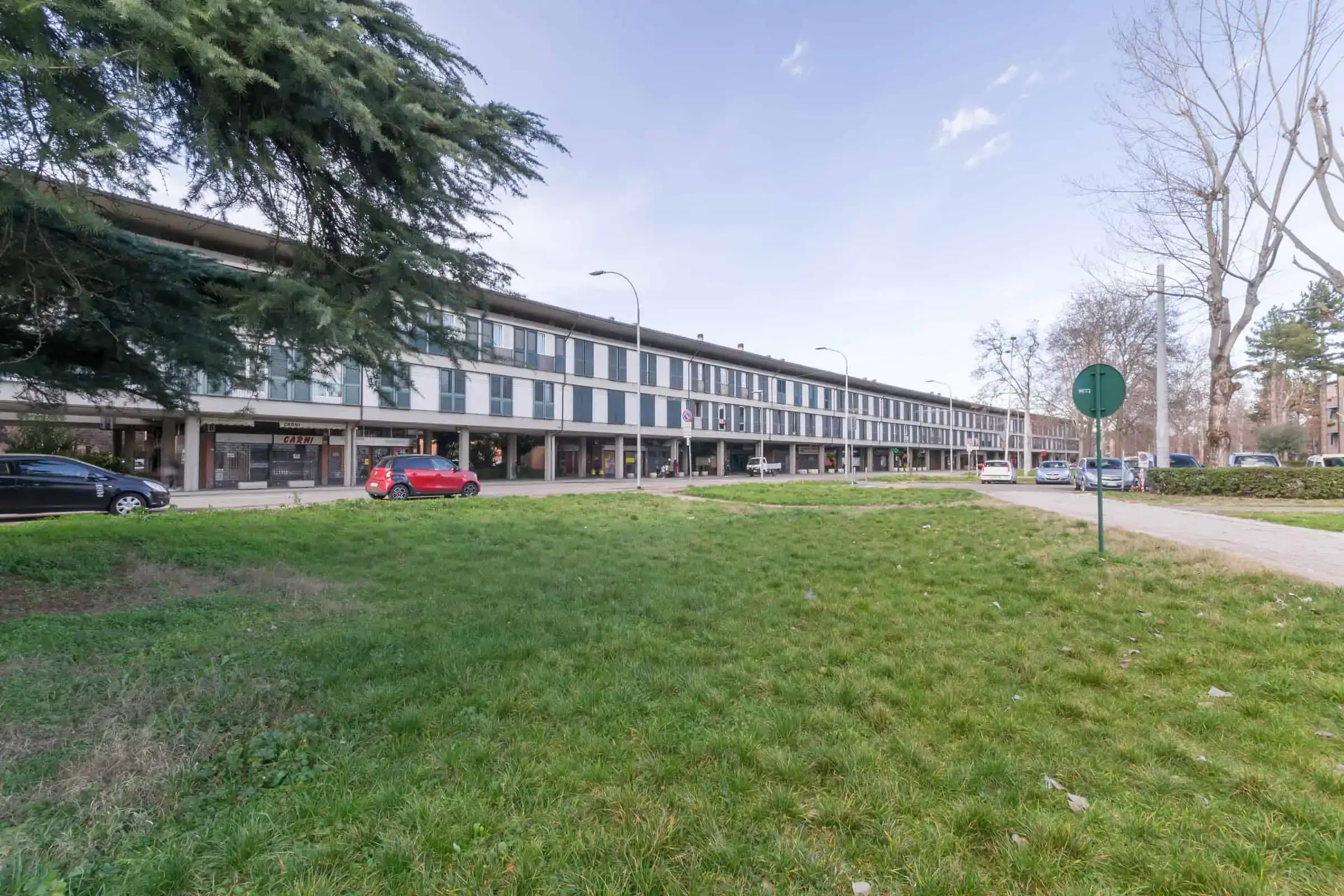 edificio moderno con vetrate su strada alberata