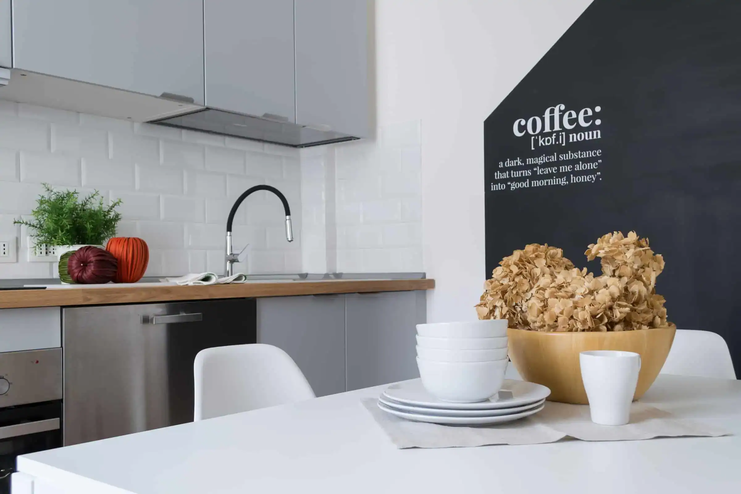cucina moderna con piante e stoviglie bianche