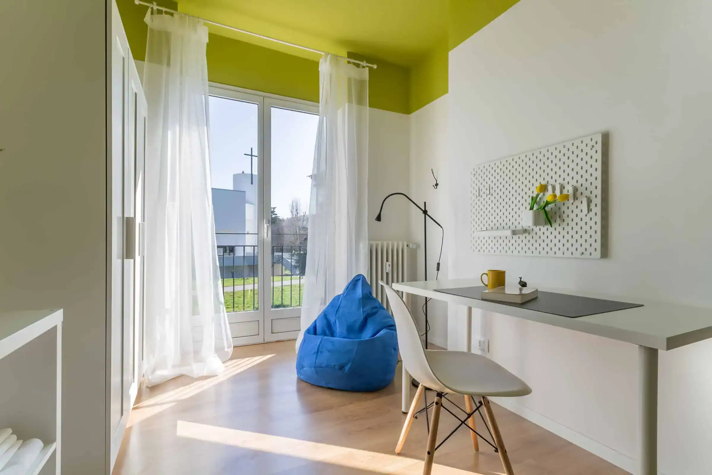 stanza con sedia e pouf blu vicino a una finestra